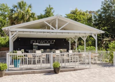 Idlewood outdoor bar pavilion with white high-top tables beside the pool