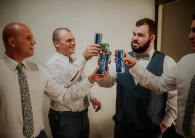 Groomsmen in shirts and ties toasting with beer cans before the wedding