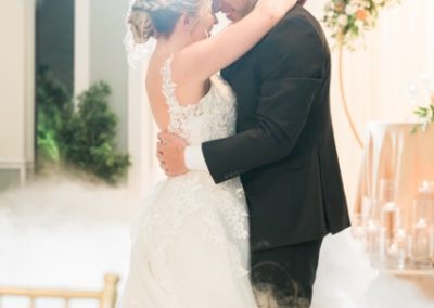 Bride and groom embracing during a foggy, candlelit first dance