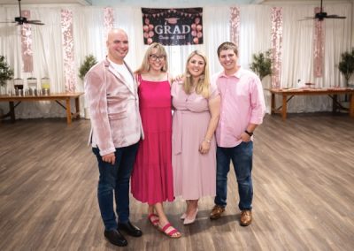 Four guests posing at a pink-themed Class of 2024 graduation party