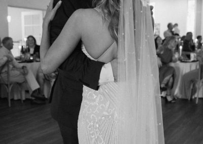 Newlyweds embracing during their first dance, in black and white