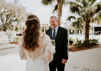 Bride's first look with her father by the pool, both smiling