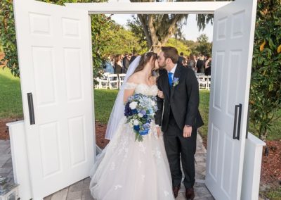 Newlyweds kissing framed by open white doors after the ceremony