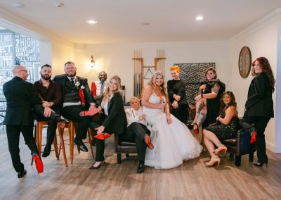 Wedding party posing playfully in the venue lounge, showing off red-soled heels