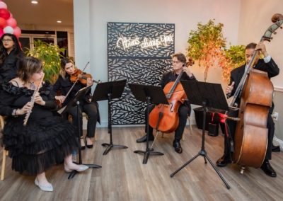 Musicians on flute, violin, cello and bass performing at an indoor reception