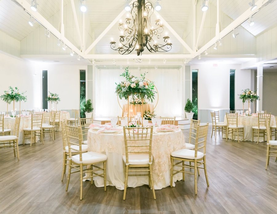 The Azalea Room in full, set with round tables beneath a wrought-iron chandelier